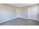 Bedroom with sleek gray hardwood floors, painted gray walls, and a bright white closet at 4620 Central Dr, Stone Mountain, GA 30083