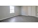 Cozy bedroom with a bright white window, gray walls, and sleek gray hardwood floors at 4620 Central Dr, Stone Mountain, GA 30083