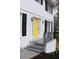 Inviting yellow front door with black shutters and modern fixtures on a charming two-story home at 4620 Central Dr, Stone Mountain, GA 30083