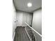Upstairs hallway with two doors, leading to bedrooms with vinyl floors, and staircase with white railing at 4620 Central Dr, Stone Mountain, GA 30083