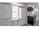 Bright kitchen with white cabinetry, stainless steel appliances, and contrasting black accents at 4620 Central Dr, Stone Mountain, GA 30083