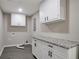 Laundry room with white cabinets, granite countertop and updated lighting at 4620 Central Dr, Stone Mountain, GA 30083