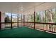 Spacious screened porch with green carpet and a view of the wooded backyard at 4620 Central Dr, Stone Mountain, GA 30083