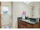 Bathroom featuring dark cabinets, sink, shower with patterned curtain, and a window for natural light at 5156 Olive Branch Cir, Powder Springs, GA 30127