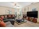 Comfortable living room with a ceiling fan, decorative brick fireplace, and plush sectional sofa at 5156 Olive Branch Cir, Powder Springs, GA 30127