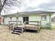 The home's backyard with lawn and minimal landscaping with steps leading onto porch at 2022 Cook Rd, Decatur, GA 30032