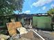 Back exterior view of the home with fire damage and debris on the ground at 2022 Cook Rd, Decatur, GA 30032