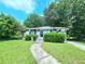 Exterior view of damaged single story home with overgrown yard and debris at 2022 Cook Rd, Decatur, GA 30032
