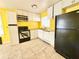 Features tile flooring, white cabinets, black refrigerator, and an electric range at 2022 Cook Rd, Decatur, GA 30032