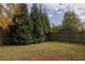 Spacious back yard with mature trees and lawn, enclosed by a wooden fence, providing privacy at 1000 Bozeman Dr, Atlanta, GA 30341
