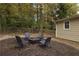 Back yard with a fire pit and chairs surrounded by wood fencing and mature trees, perfect for outdoor gatherings at 1000 Bozeman Dr, Atlanta, GA 30341