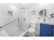 White bathroom with walk-in shower, pebble floor, and blue vanity cabinet at 2086 Mountain Creek Ct, Stone Mountain, GA 30087
