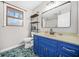 Bathroom with blue vanity cabinet, large mirror, and mosaic tile floor at 2086 Mountain Creek Ct, Stone Mountain, GA 30087