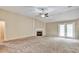 Vast living room featuring a fireplace, ceiling fan, and a door leading to outdoor spaces with neutral carpet at 501 Barhams Ridge Dr, Mcdonough, GA 30252