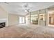 Expansive living room boasts a fireplace, ceiling fan, and open access to the kitchen, complemented by neutral carpet at 501 Barhams Ridge Dr, Mcdonough, GA 30252