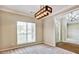 Inviting office space featuring neutral walls and carpet, large window, and white trim with modern chandelier at 501 Barhams Ridge Dr, Mcdonough, GA 30252