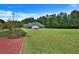 Expansive lush green backyard with mature trees, a well manicured lawn, and a glimpse of the brick home at 501 Barhams Ridge Dr, Mcdonough, GA 30252