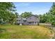 Large, fenced backyard of grey two-story home with mature trees at 3989 Woodland Se Cir, Conyers, GA 30013