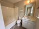 This bathroom features a shower-tub combo, toilet, vanity, and shelving units for storage at 3989 Woodland Se Cir, Conyers, GA 30013