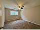 This bedroom features neutral walls, a ceiling fan, carpet, and a window for natural light at 3989 Woodland Se Cir, Conyers, GA 30013