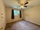 Bedroom with window, carpet floors, ceiling fan, and neutral colored walls at 3989 Woodland Se Cir, Conyers, GA 30013