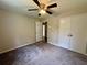 Bedroom with ceiling fan, carpet, window, and closet doors at 3989 Woodland Se Cir, Conyers, GA 30013