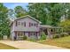 Gray two-story home with red shutters, concrete driveway, and a charming covered front porch at 3989 Woodland Se Cir, Conyers, GA 30013