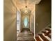 Inviting hallway featuring hardwood floors, a decorative light fixture, and access to the kitchen at 3989 Woodland Se Cir, Conyers, GA 30013
