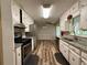 Galley-style kitchen with stainless appliances, granite countertops, and wood-look flooring at 3989 Woodland Se Cir, Conyers, GA 30013