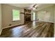 Spacious living room with stone fireplace, wood floors, and large windows for natural light at 3989 Woodland Se Cir, Conyers, GA 30013