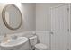 Clean half-bathroom featuring an oval mirror, pedestal sink, and a modern toilet at 109 Mill Creek Dr, Canton, GA 30115