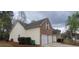 Side view of the home features brick and siding, manicured lawn, and two-car garage at 1956 Cutters Mill Way, Lithonia, GA 30058
