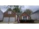 Charming brick home featuring a two-car garage and manicured landscaping at 1956 Cutters Mill Way, Lithonia, GA 30058