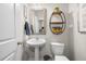 Neat half bath with a pedestal sink, toilet, and decoratively adorned with a round shelf at 2515 Norwood Park Xing, Atlanta, GA 30340