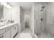 Modern bathroom with a tiled shower, dual sinks, white cabinets, and grey floors at 3192 Eastham Run Dr, Dacula, GA 30019