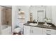 Well-lit bathroom with granite countertop, decorative shelving, and a shower-tub combination at 5300 Peachtree Rd # 0507, Atlanta, GA 30341