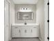 Bathroom featuring white vanity with black hardware, a gray patterned floor, and large mirror at 5427 Fieldgreen Dr, Stone Mountain, GA 30088