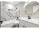 Modern bathroom featuring white marble-style tile shower, black fixtures, and oval mirror at 5427 Fieldgreen Dr, Stone Mountain, GA 30088