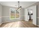 Dining room with new light fixture, flooring, large window, and view into the kitchen at 5427 Fieldgreen Dr, Stone Mountain, GA 30088