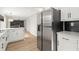 Kitchen showcasing stainless steel refrigerator, white cabinets and subway tile with view into the living room at 5427 Fieldgreen Dr, Stone Mountain, GA 30088