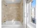 Bright bathroom with shower-tub combination and stone tile at 195 14Th Ne St # 2105, Atlanta, GA 30309