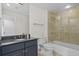 Modern bathroom with granite countertops, large mirror, and tiled shower and tub combo at 195 14Th Ne St # 2105, Atlanta, GA 30309