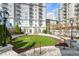 Beautifully landscaped courtyard with a lush lawn, trees and manicured bushes, and a cityscape backdrop at 195 14Th Ne St # 2105, Atlanta, GA 30309