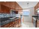 Well-lit kitchen featuring granite counters, wooden cabinets, stainless steel appliances, and colorful tile backsplash at 195 14Th Ne St # 2105, Atlanta, GA 30309