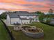 Sunset aerial view of a white modern farmhouse and backyard pond with gazebo at 3735 Hamilton Mill Rd, Buford, GA 30519