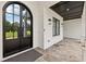 Close-up of a modern entryway with a black arched double-door, stone flooring, and outdoor lighting at 3735 Hamilton Mill Rd, Buford, GA 30519