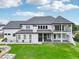 Back exterior view of a modern white farmhouse with a second story balcony at 3735 Hamilton Mill Rd, Buford, GA 30519