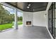 Covered patio featuring a fireplace, ceiling fan, and black-framed sliding doors, perfect for outdoor living at 3735 Hamilton Mill Rd, Buford, GA 30519