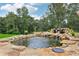 Backyard stone pond with waterfall feature provides a natural retreat at 3735 Hamilton Mill Rd, Buford, GA 30519