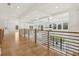 Upstairs hallway showcasing hardwood floors, black metal railing, and recessed lighting throughout at 3735 Hamilton Mill Rd, Buford, GA 30519